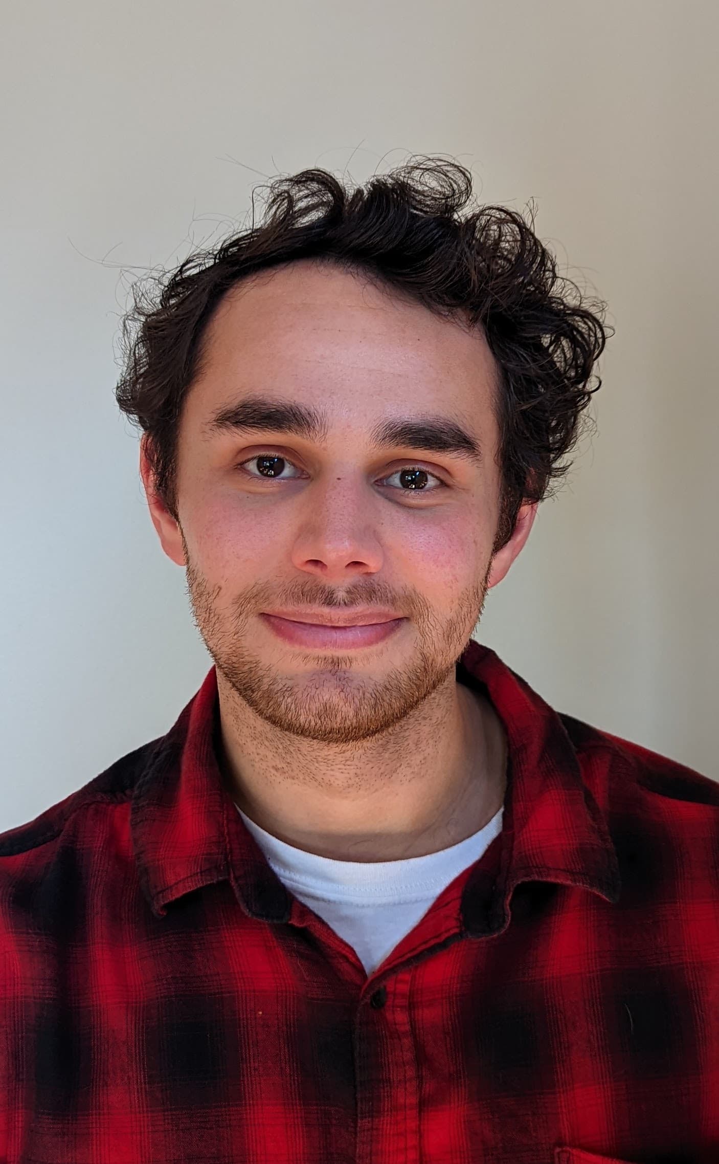 Colton Almaraz smiling in a red flannel shirt